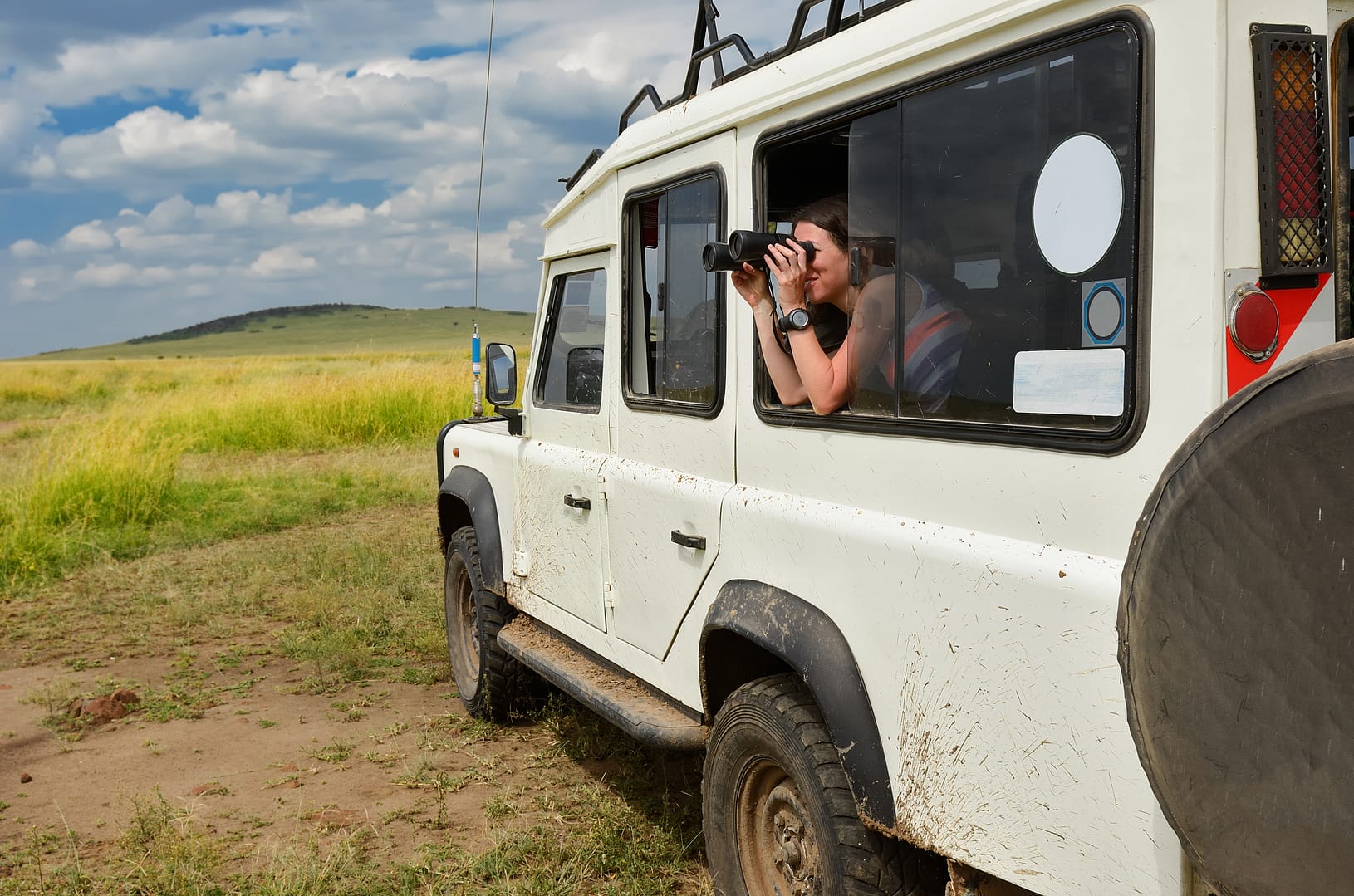 What is a safari? Woman on a game drive taking photographs of wildlife